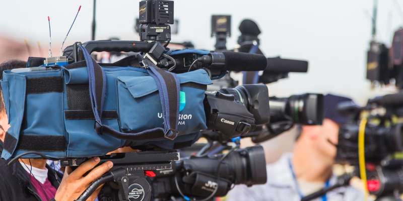 a cameraman pointing his camera off picture