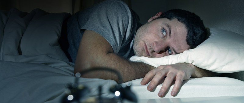 man lying awake in bed