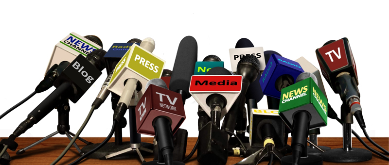 a bunch of microphones from different press offices set up on a table