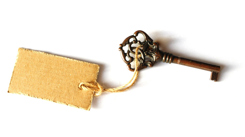 an old ornate key wit a tag tied to it