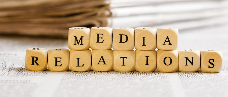 wooden dice-sized cubes with letters spelling out media relations