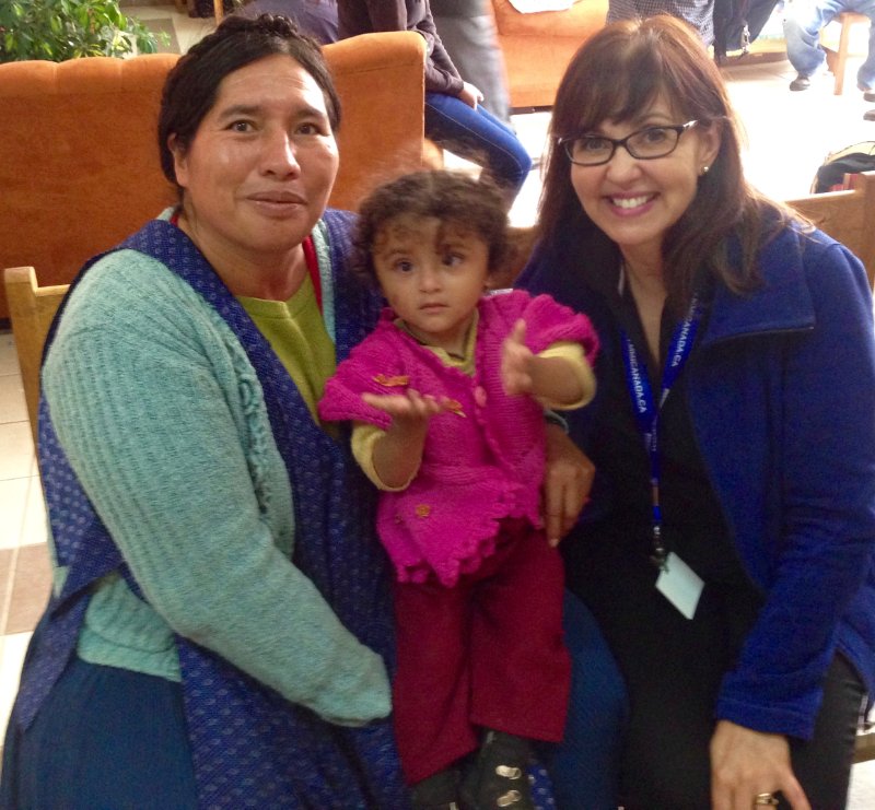 two adults and a toddler posing for the camera