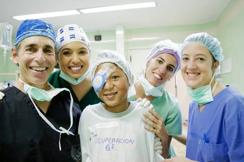 medical staff around a young girl with an eye patch