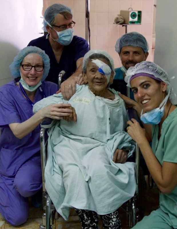 medical staff surrounding a woman in a wheelchair with an eye bandaged up