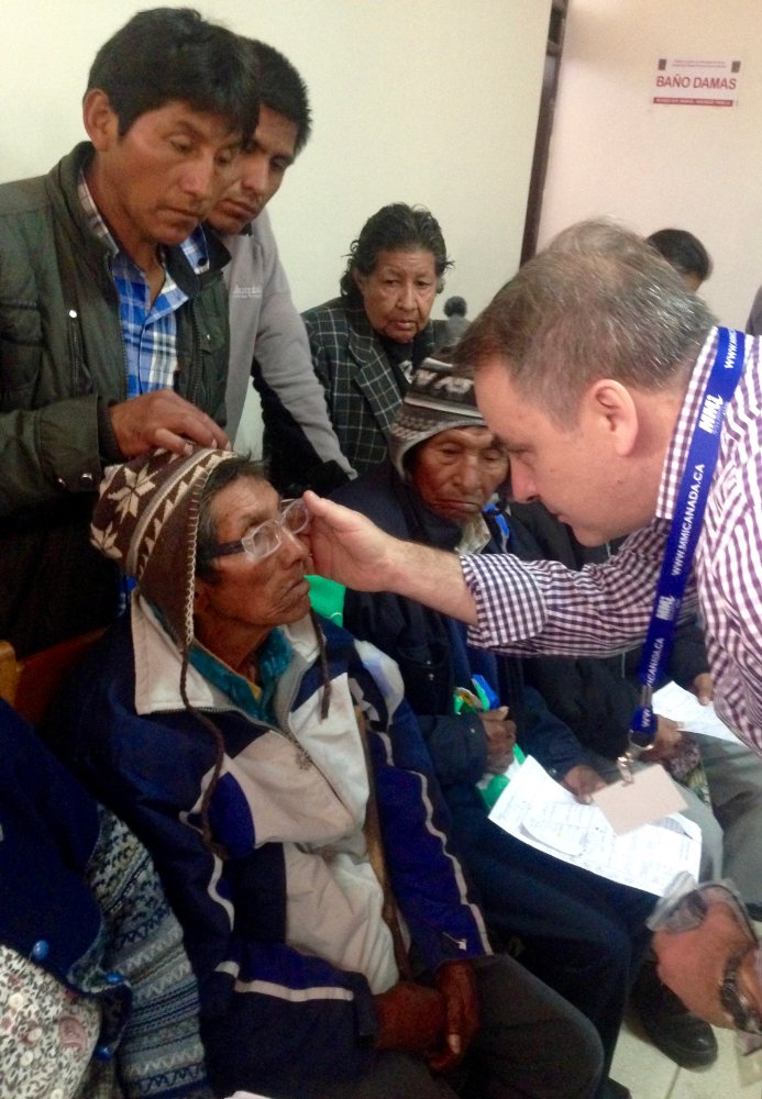 a man putting glasses on an old woman